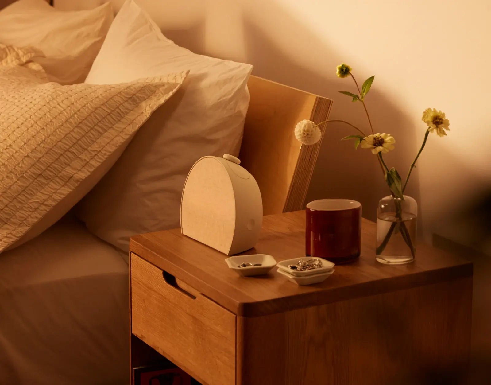 Hatch Restore 3 casting a warm light on a bedside table